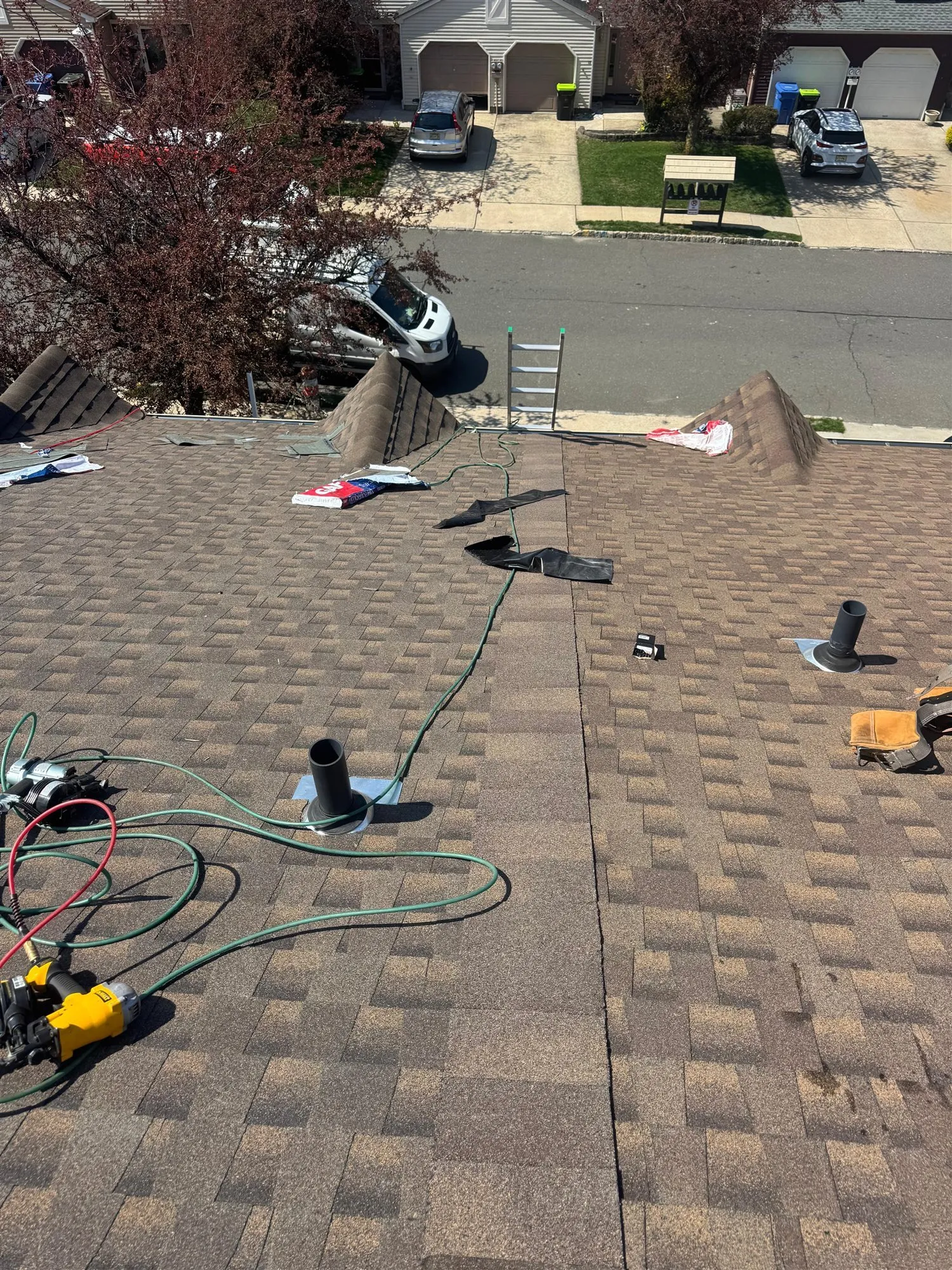 Asphalt shingle roof with tools during a leak repair