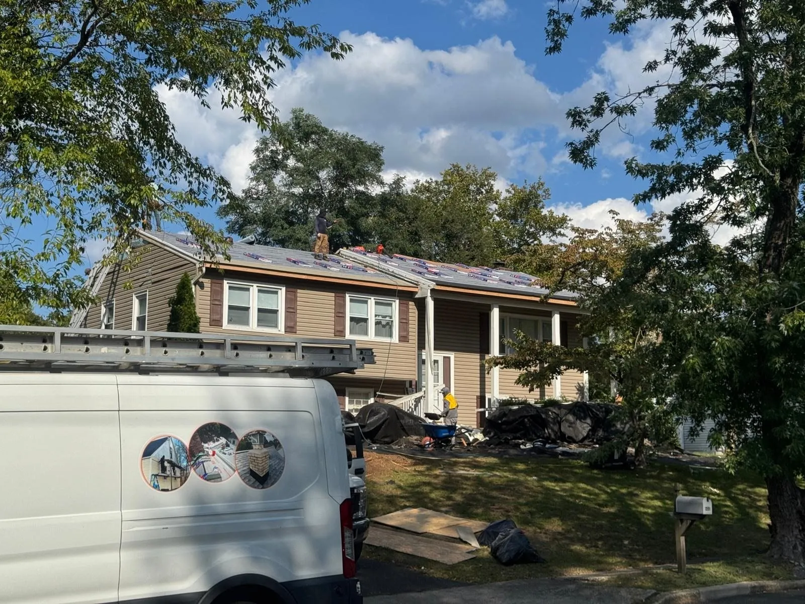 Roofing work truck parked outside a split-level home
