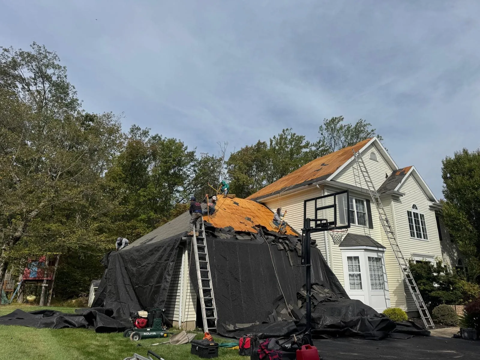 House wrapped in tarps during a roof tear-off