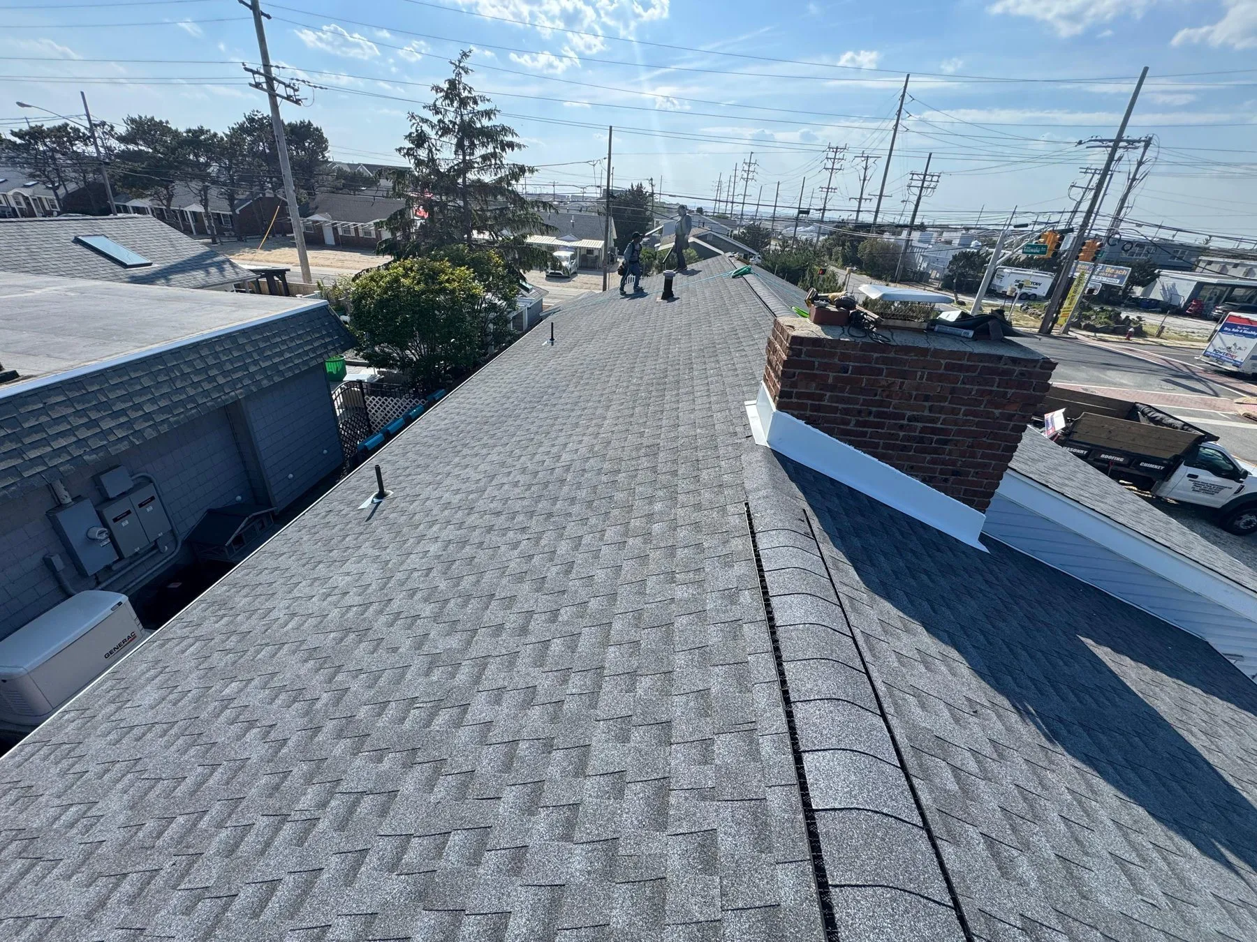 Brick chimney with new aluminum counter-flashing on a freshly shingled roof