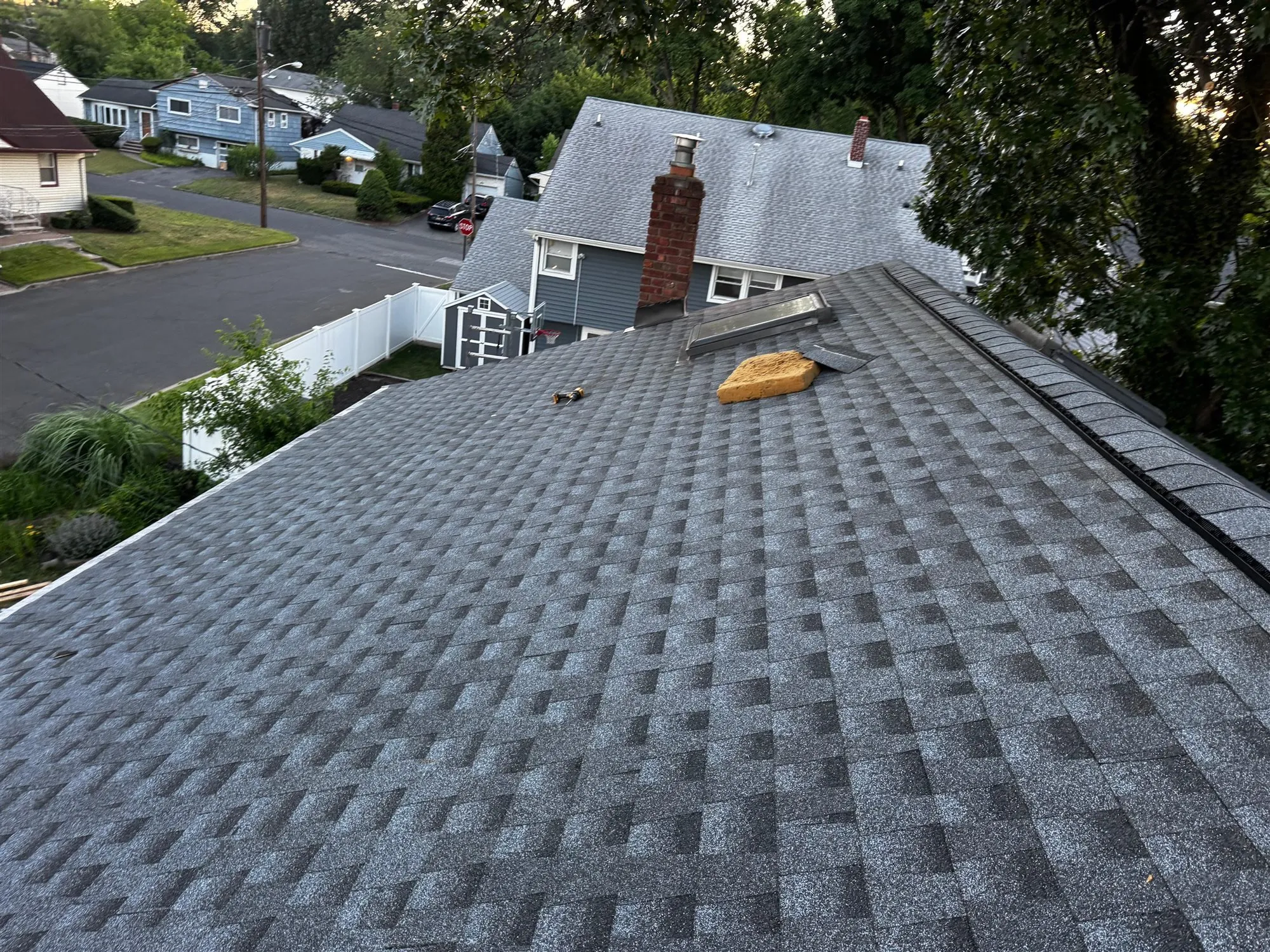 Finished gray shingle roof with a brick chimney