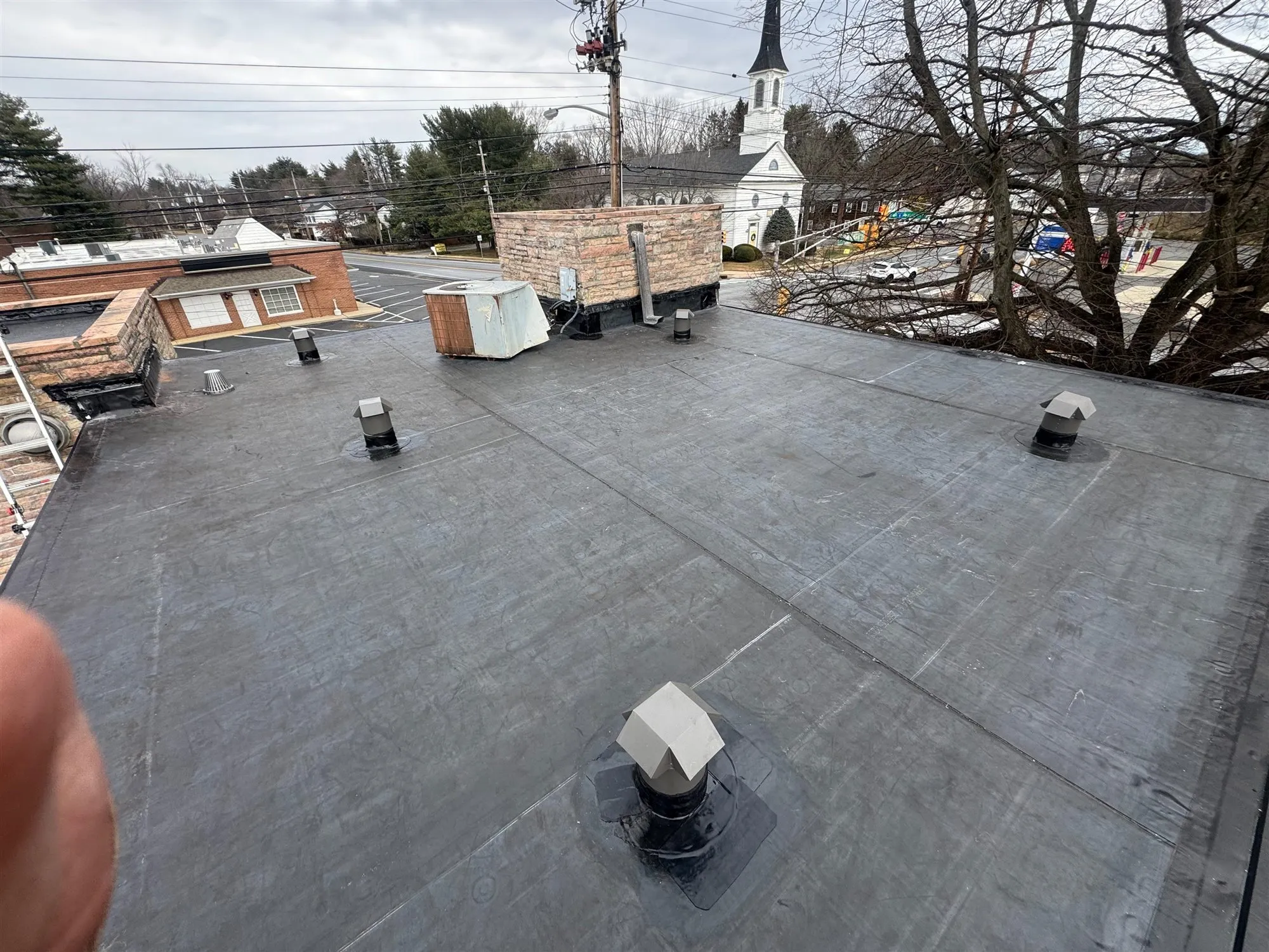 Low-slope roof with a new dark membrane and roof vents
