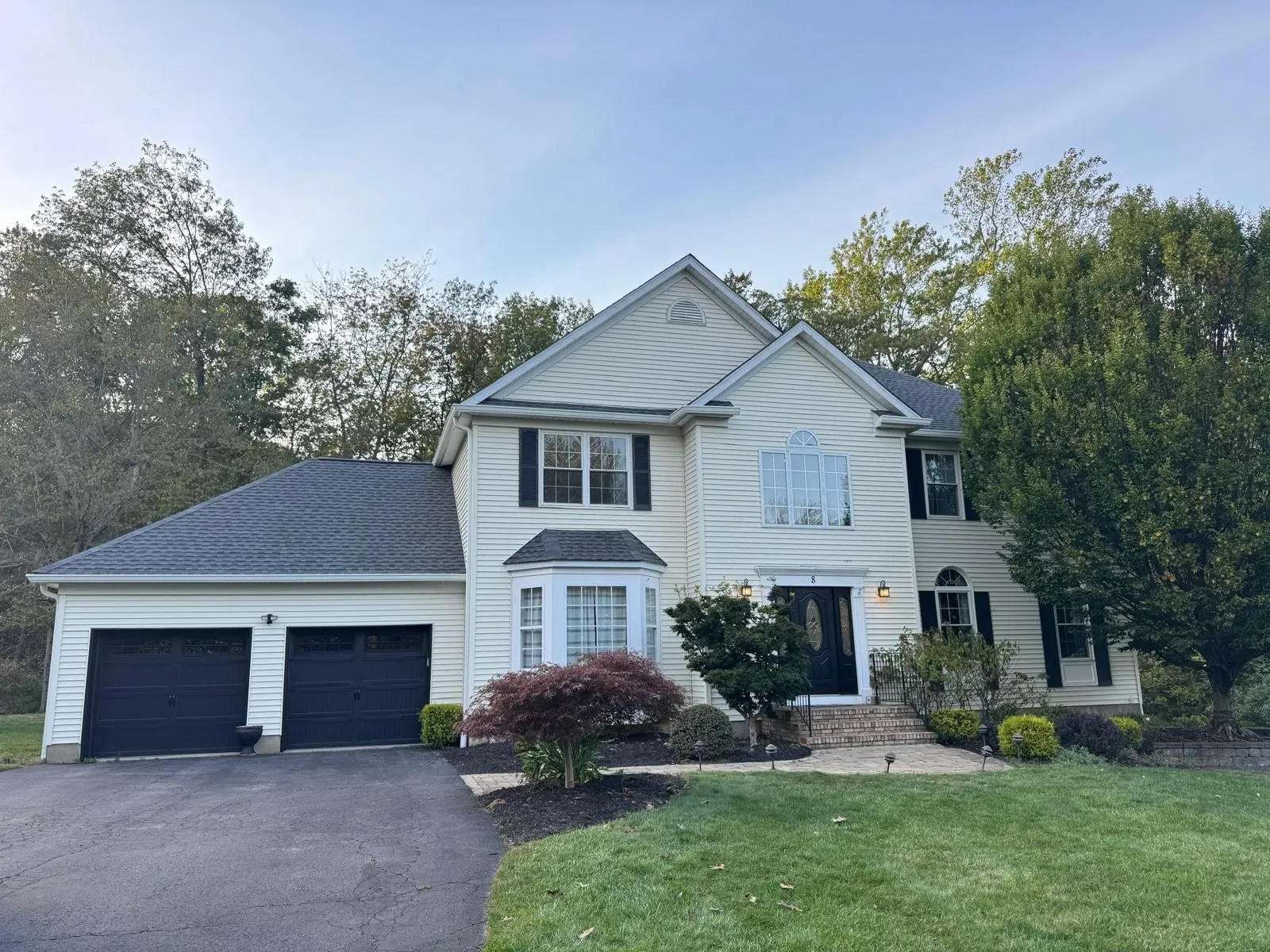 Two-story white colonial home with new dark asphalt shingle roof in North Jersey
