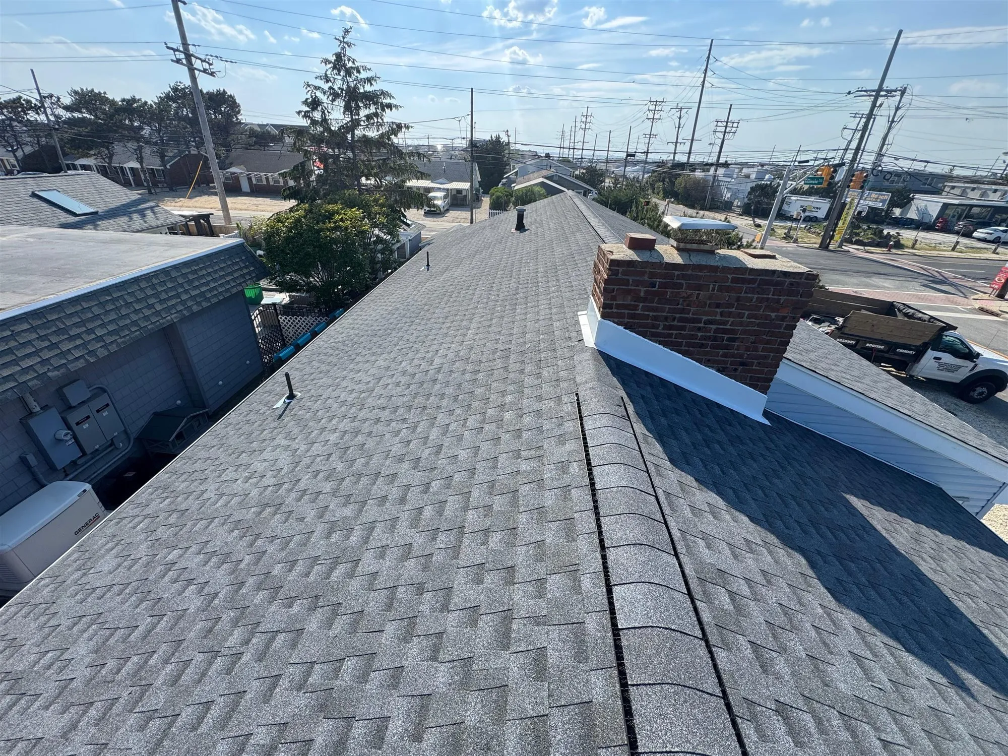 New gray architectural shingle roof with white chimney flashing on a New Jersey home