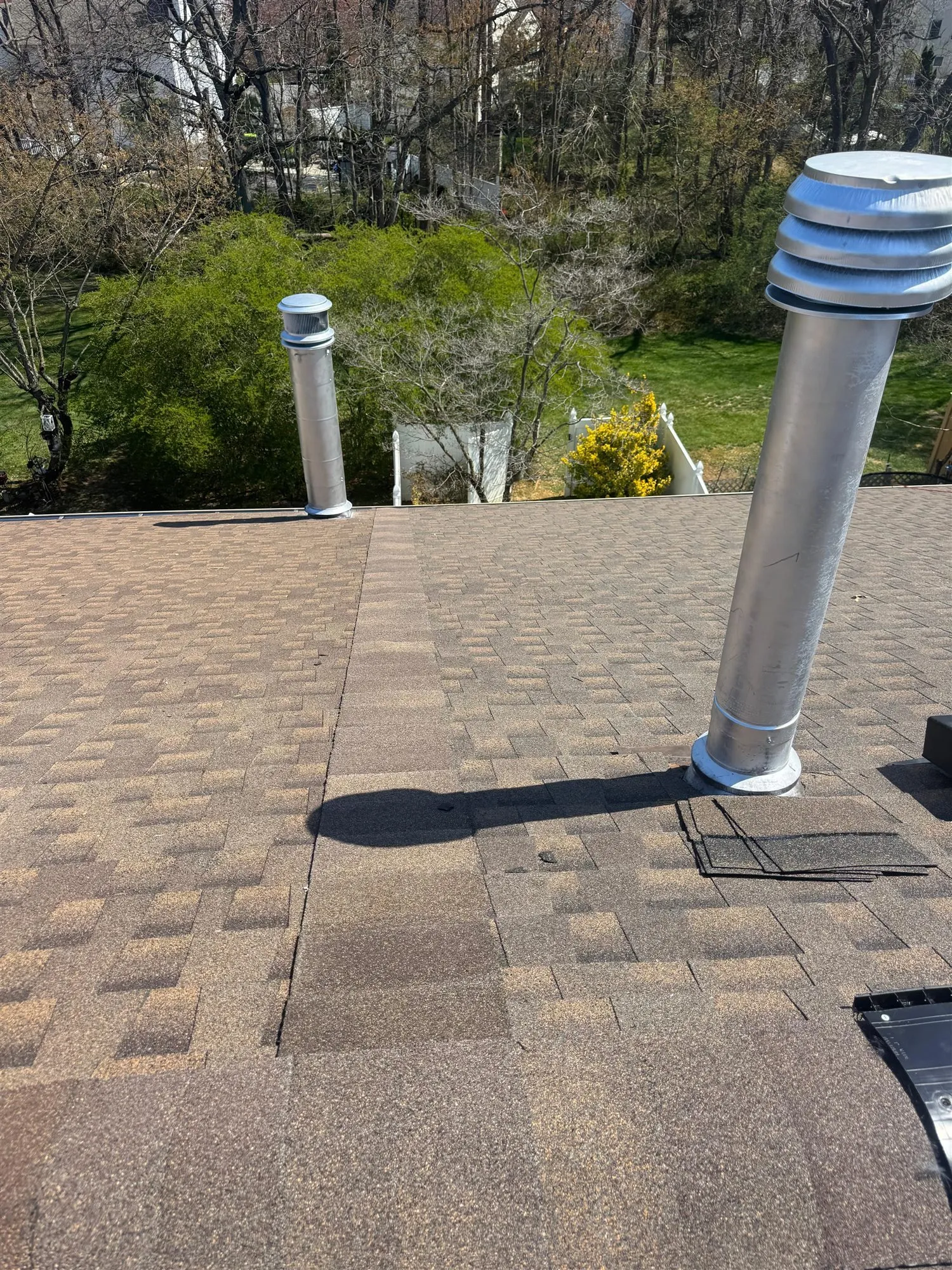 Metal vent pipes and pipe boot flashing on an asphalt shingle roof