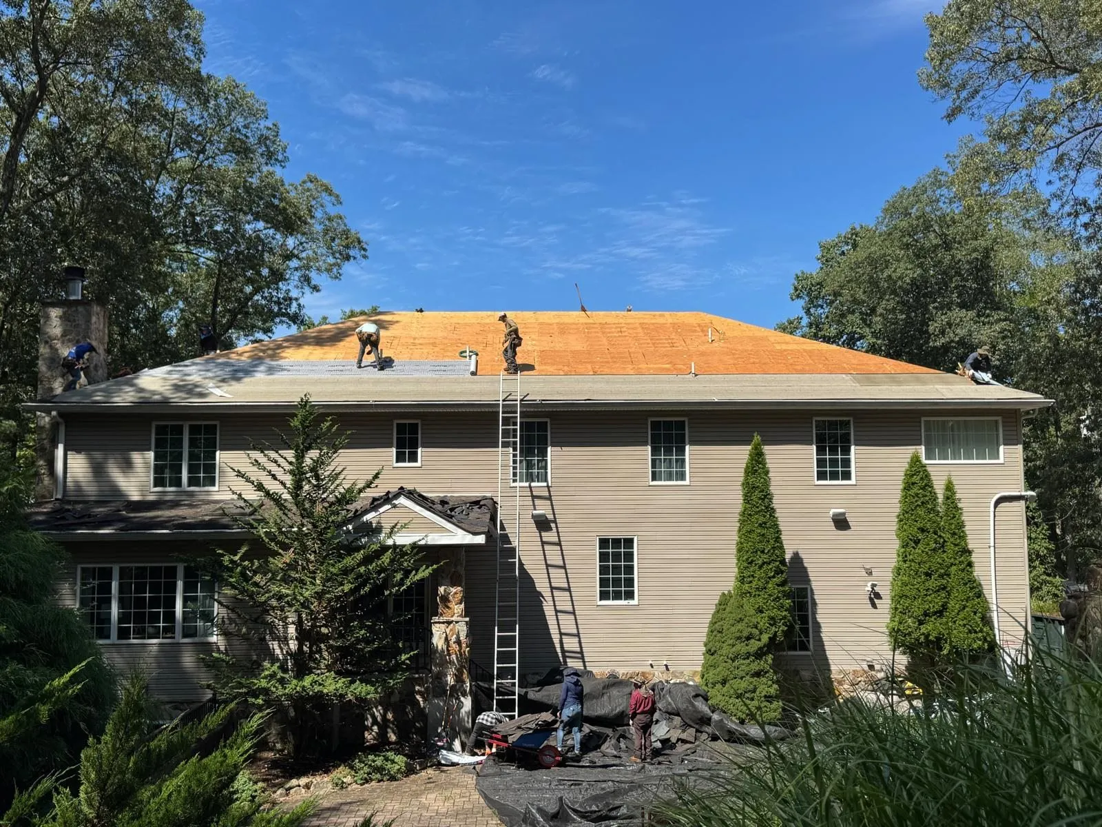 Imperial crew stripping a two-story home down to the roof deck during a roof replacement