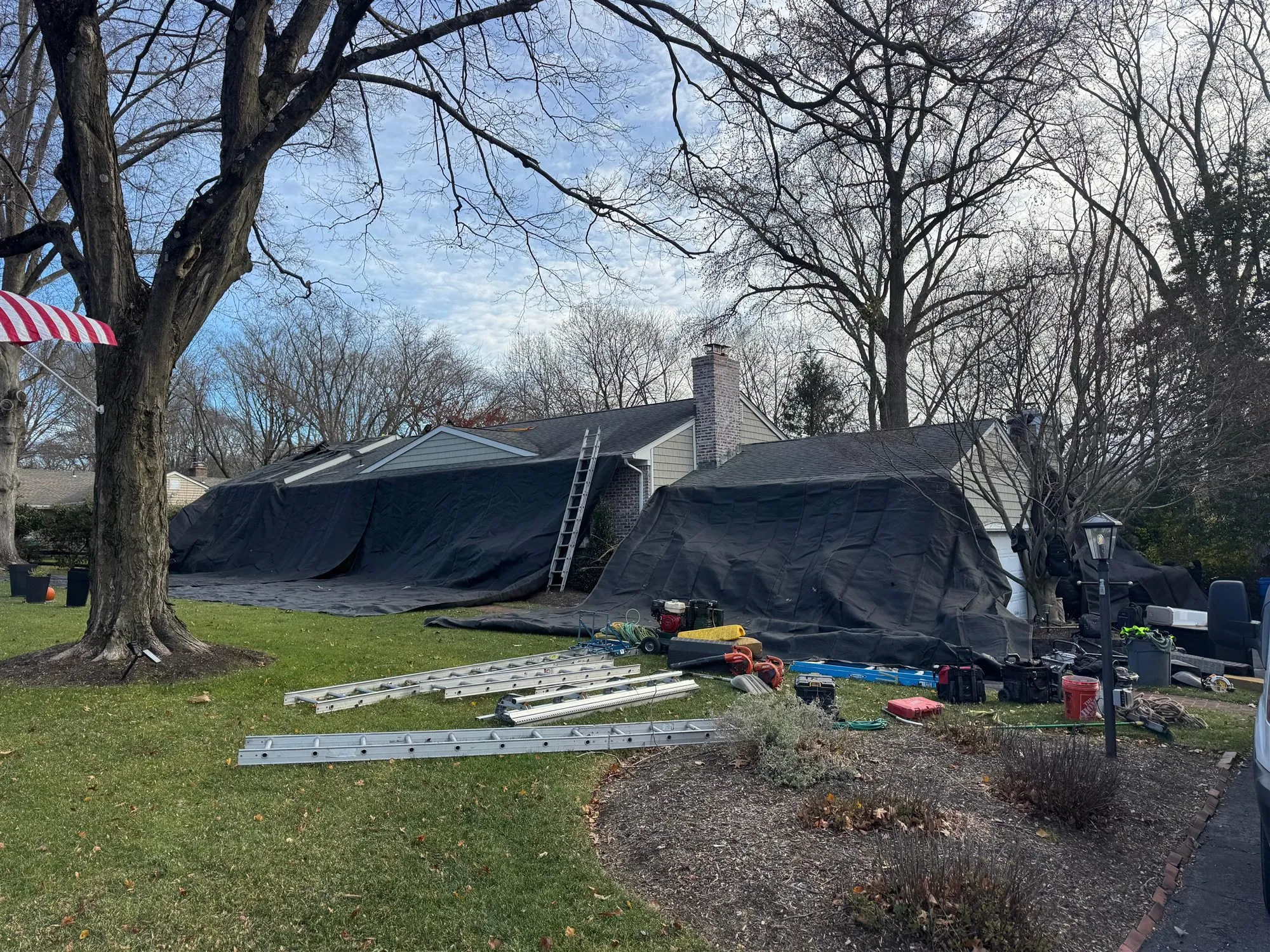 House tarped to protect the landscaping during a roof tear-off